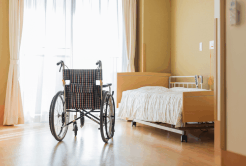 Image is of a nursing home room with an empty bed and empty wheelchair, concept of Melbourne nursing home abuse & neglect lawyer