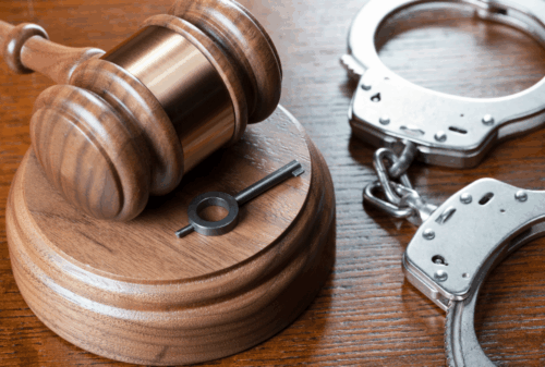 Image is of a judge's gavel next to a pair of handcuffs, concept of Cocoa Beach record sealing and expungement lawyer