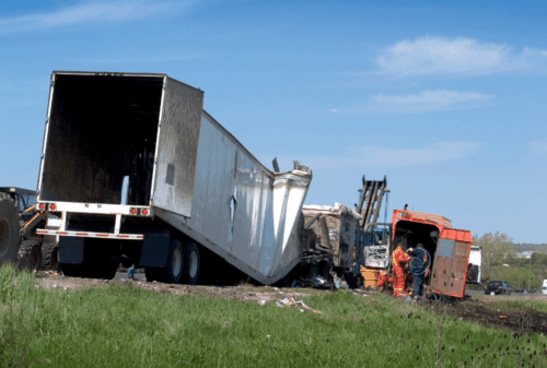 Image is of a wrecked semi-truck on the side of the road, concept of Cocoa Beach truck accident lawyer
