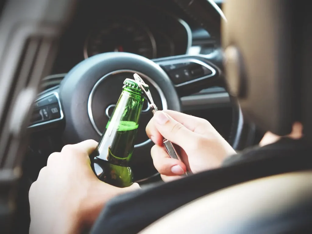Person opening beer while driving.