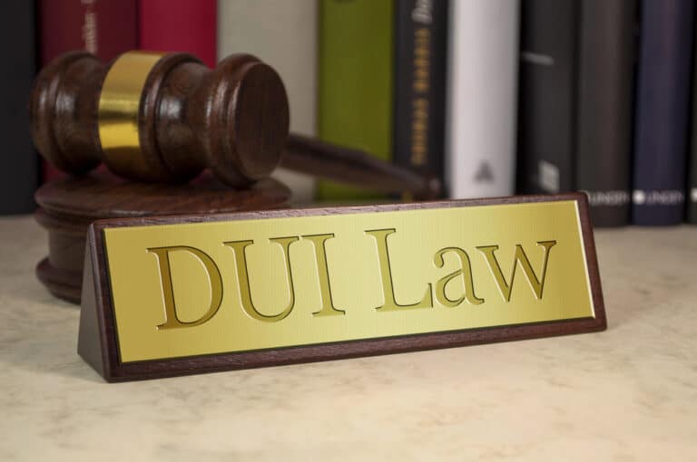 Image is of a courtroom gavel next to a DUI law sign, representing legal consequences and rights involved in Florida DUI checkpoints.