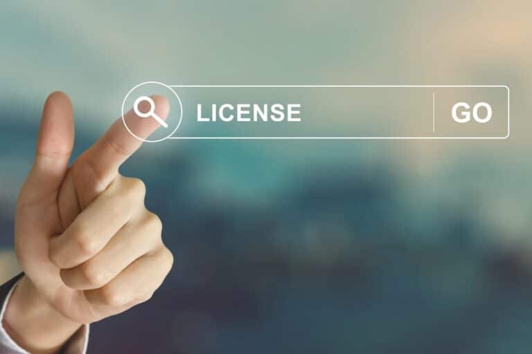 Image is of a hand pointing at an online license search bar, concept of how domestic violence charges can trigger professional license reviews and regulatory scrutiny.