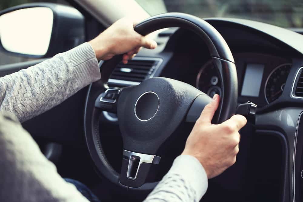 Image is of hands gripping a steering wheel inside a vehicle, representing responsible driving decisions after DUI charges