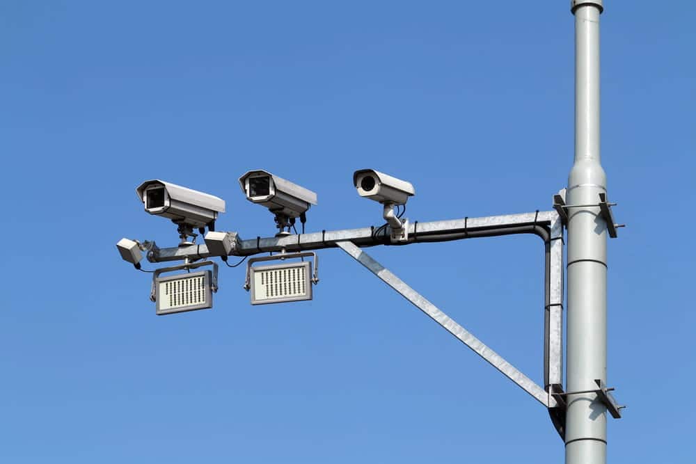 Image is of roadside traffic surveillance cameras used to capture vehicle activity and roadway footage, concept of DUI defense.