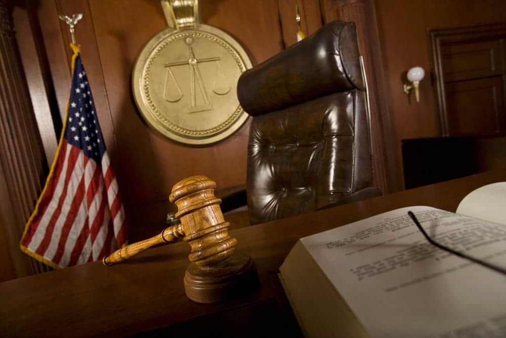 Image is of a courtroom gavel and judge bench, concept of legal consequences for violating a protective order in Cocoa Beach