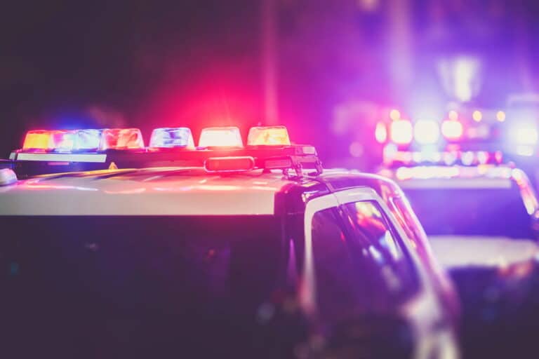 Image is of flashing police lights and an active roadside investigation scene connected to a DUI stop in Cocoa Beach at night.