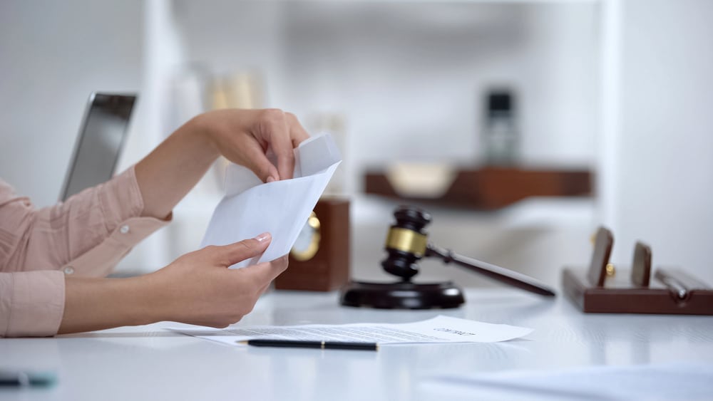 Image is of a person reviewing legal documents beside a judge's gavel, concept of legal rights after domestic violence in Cocoa Beach.