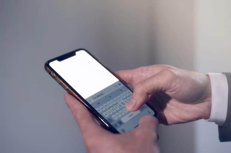 Image is of a person typing a message on a smartphone, concept of DV defense mistakes involving digital communications.