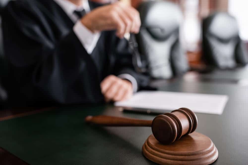 Image is of a judge with a gavel in a courtroom, concept of judicial proceedings at a DUI bond hearing.