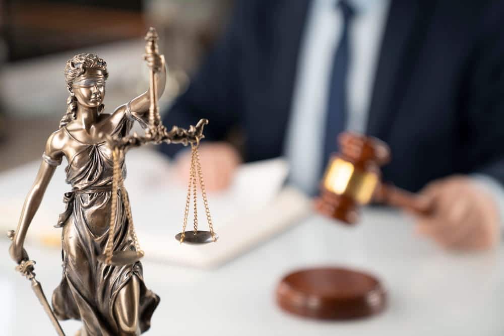 Image is of a Lady Justice statue and judge with a gavel, concept of a DV bond hearing in Cocoa Beach.