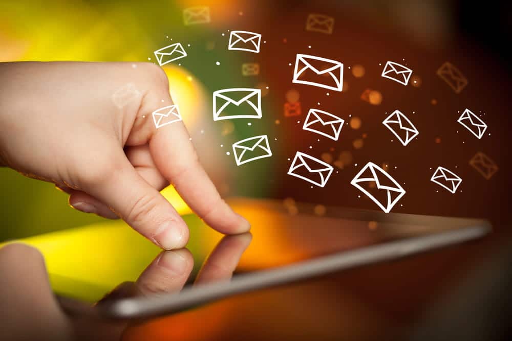 Image is of a finger touching a digital tablet with floating email icons, concept of electronic communication evidence in a Cocoa Beach DV case.